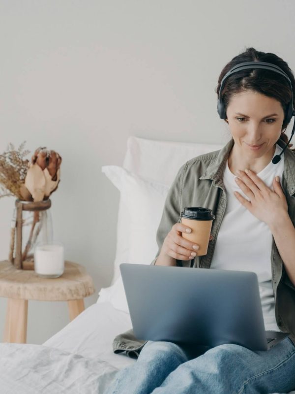 woman-life-coach-in-headset-conducts-online-consultation-by-video-call-on-laptop-in-bedroom-at-home.jpg